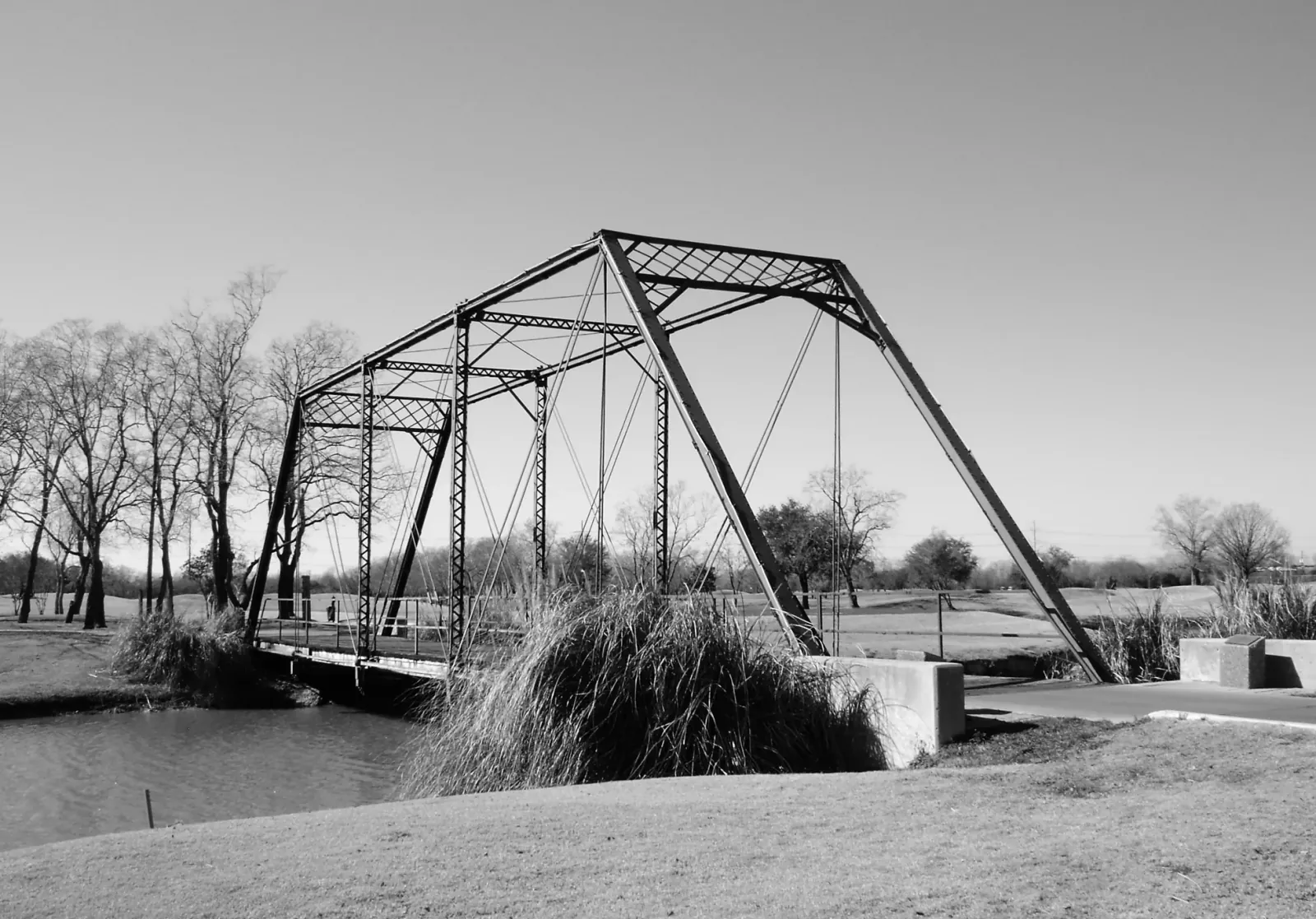 Historic black-and-white photograph of a steel truss bridge