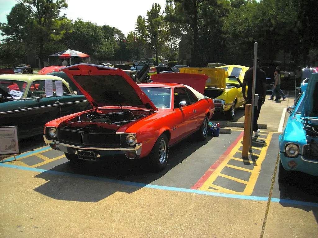 Red classic car with its hood open at a car show