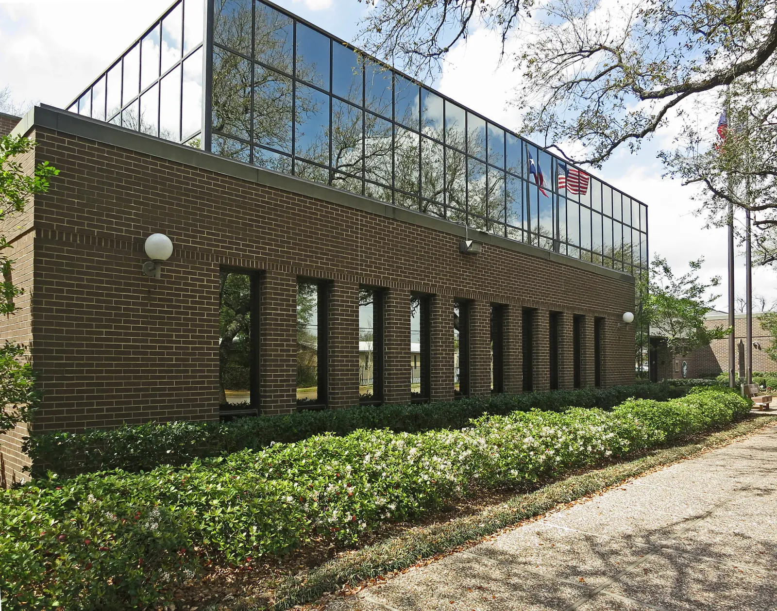Brick building beside a shaded landscaped walkway