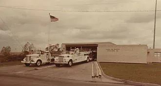 Historic photograph of buses and a low roadside building