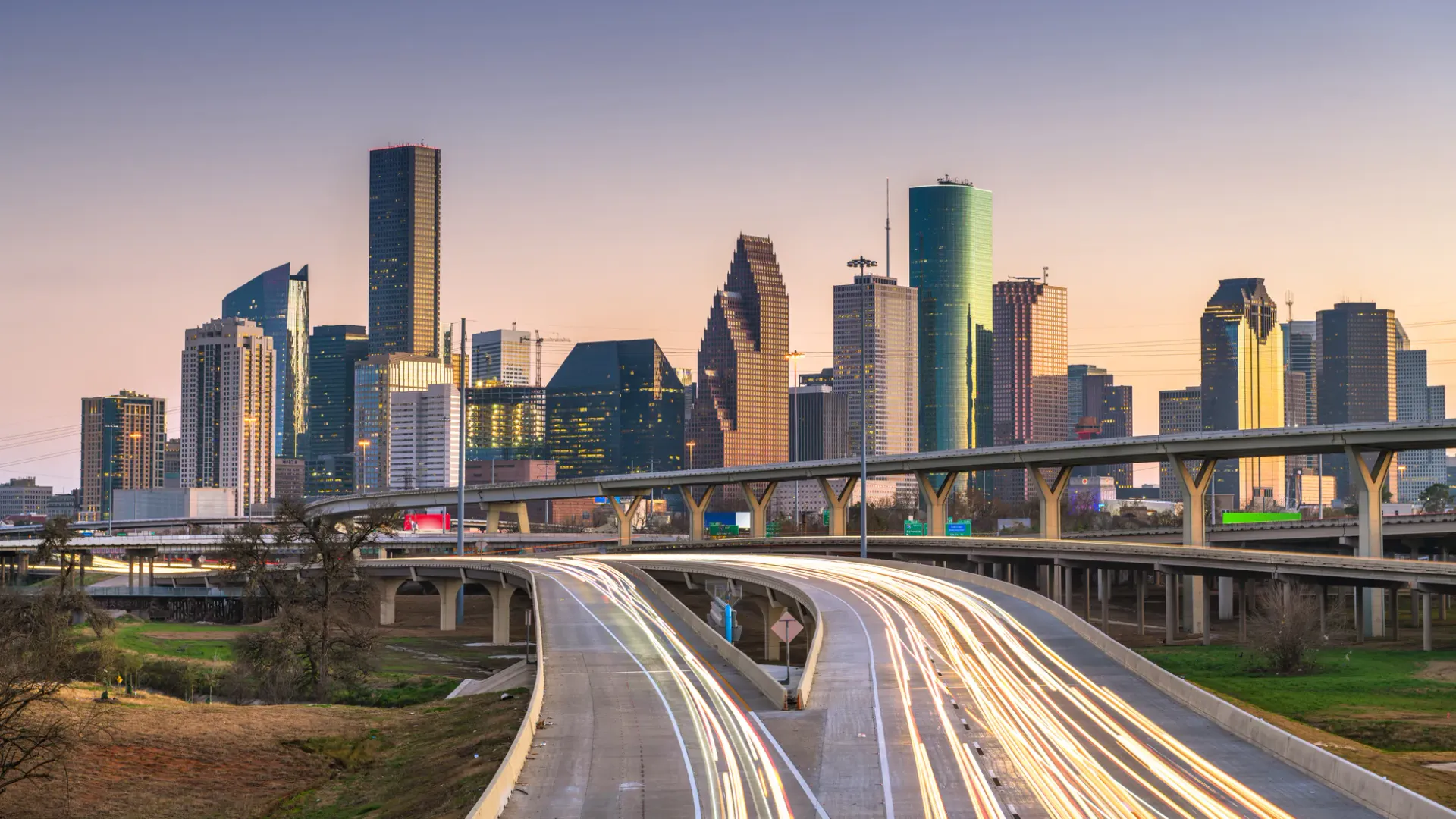 Downtown Houston skyline and freeway light trails at dusk