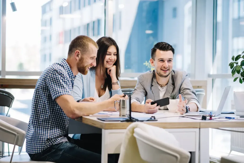 Colleagues talking together on a bench by an office window