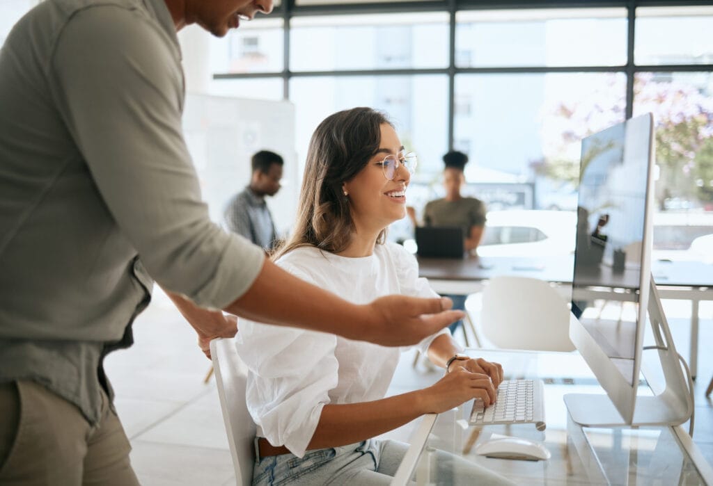 A couple is employed in an office, focusing on computer work.
