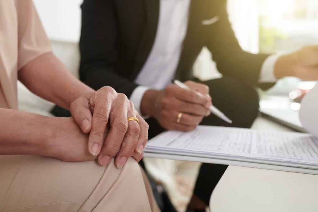 A couple reviewing and signing a life insurance document.