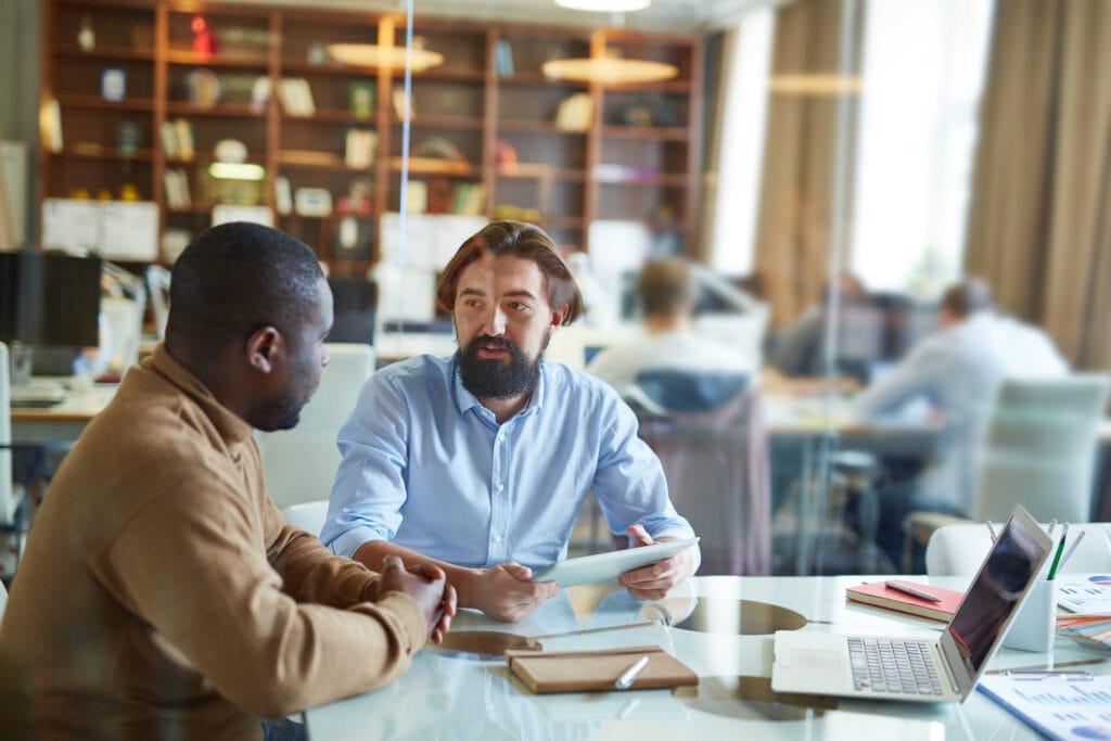 Two businessmen discussing the impact of health care reform on their businesses.