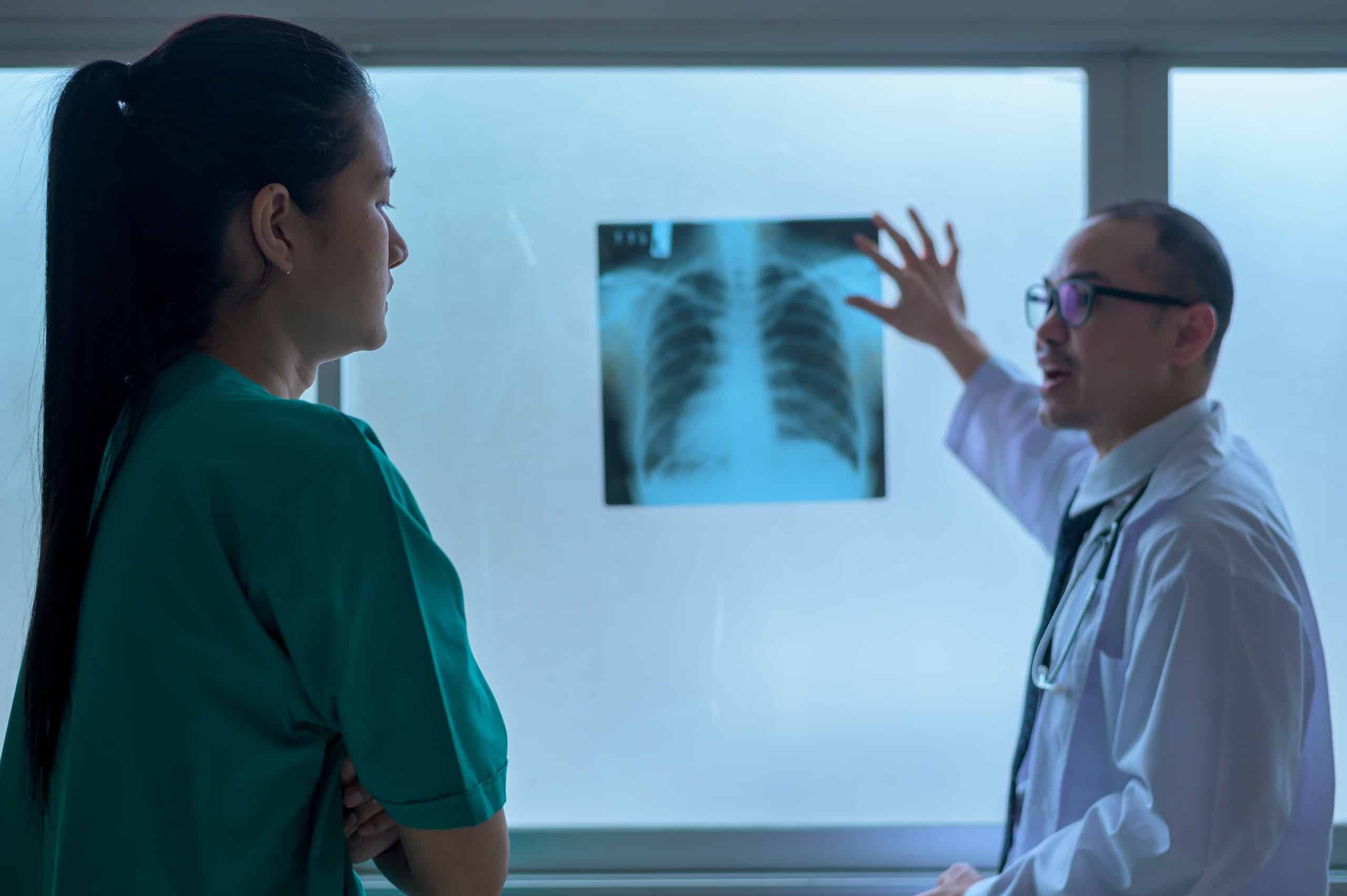 A doctor and a patient examining an x-ray to determine if wellness is the answer.