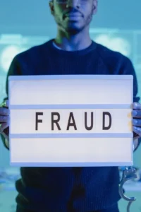 Businessman holding a “fraud” sign, symbolizing medical billing fraud and upcoding in healthcare.